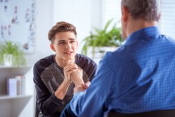 Ein Junger Mann im Gespräch mit seinem Therapeuten | © Iza Habur - izusek - Getty Images